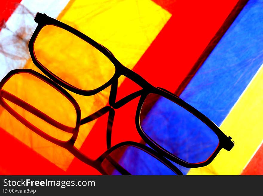 Abstract background design made from a pair of eyeglasses and numerous colors. Abstract background design made from a pair of eyeglasses and numerous colors.