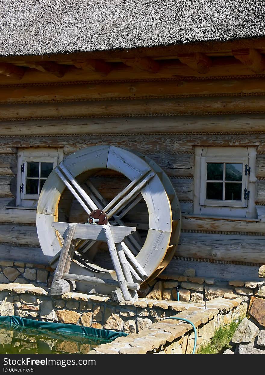 Close up mill wheel the old fashioned wooden house with thatched roof. Close up mill wheel the old fashioned wooden house with thatched roof.