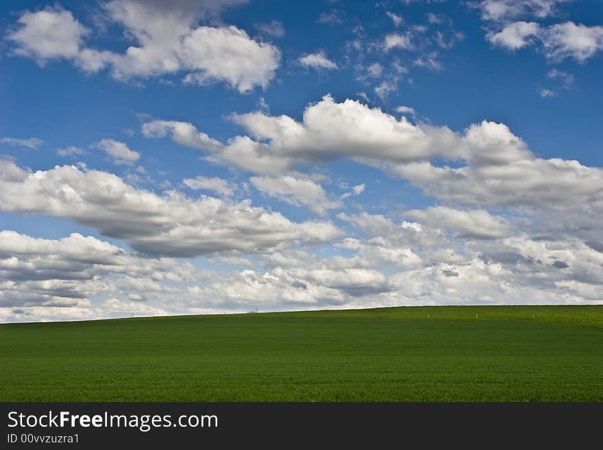 The storm is over: cloudy blue sky on green field. The storm is over: cloudy blue sky on green field