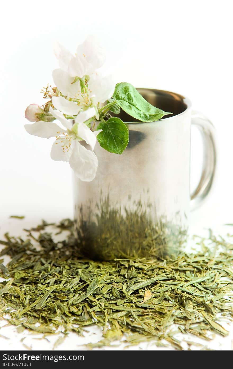 Cup of tea with flower and tea leafs, isolated on white background