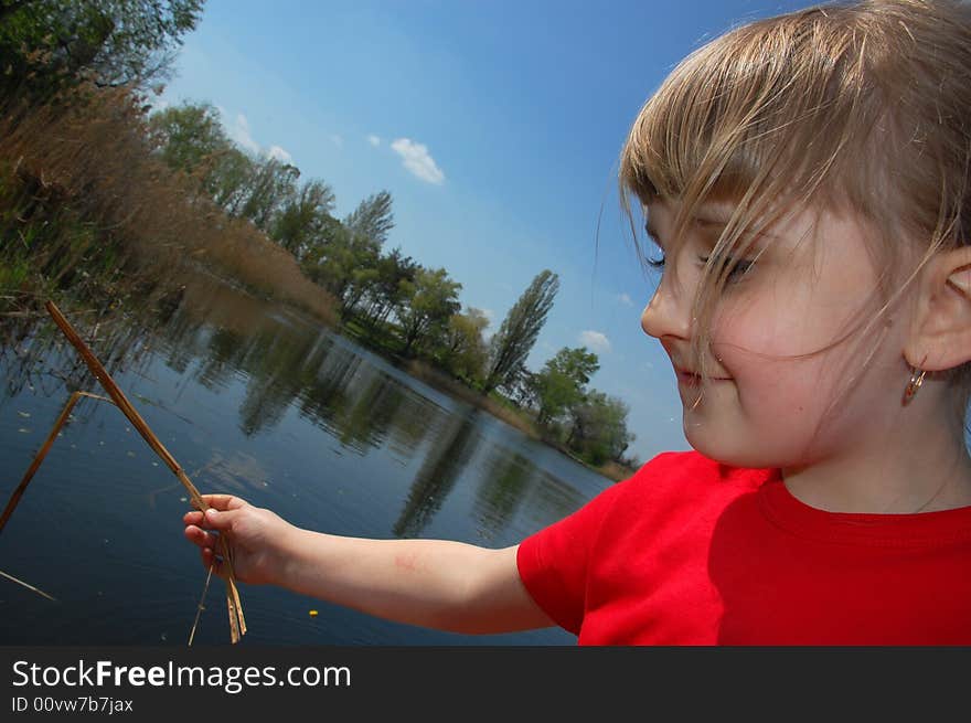 Little girl playing with a stick pretending she is fishing. Little girl playing with a stick pretending she is fishing