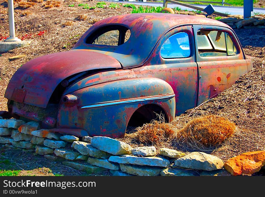 This old car has been buried in the ground. It is used as a flower pot by the owners. The trunk is empty now, by mid-spring she will be loaded with annuals. This old car has been buried in the ground. It is used as a flower pot by the owners. The trunk is empty now, by mid-spring she will be loaded with annuals.