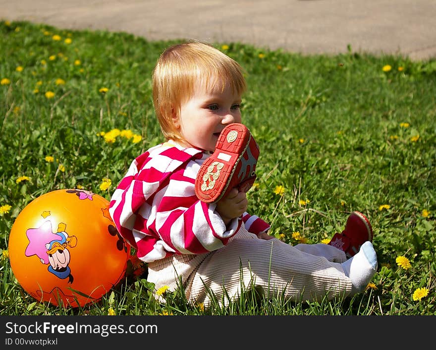 The little girl with ball on a grass. The little girl with ball on a grass