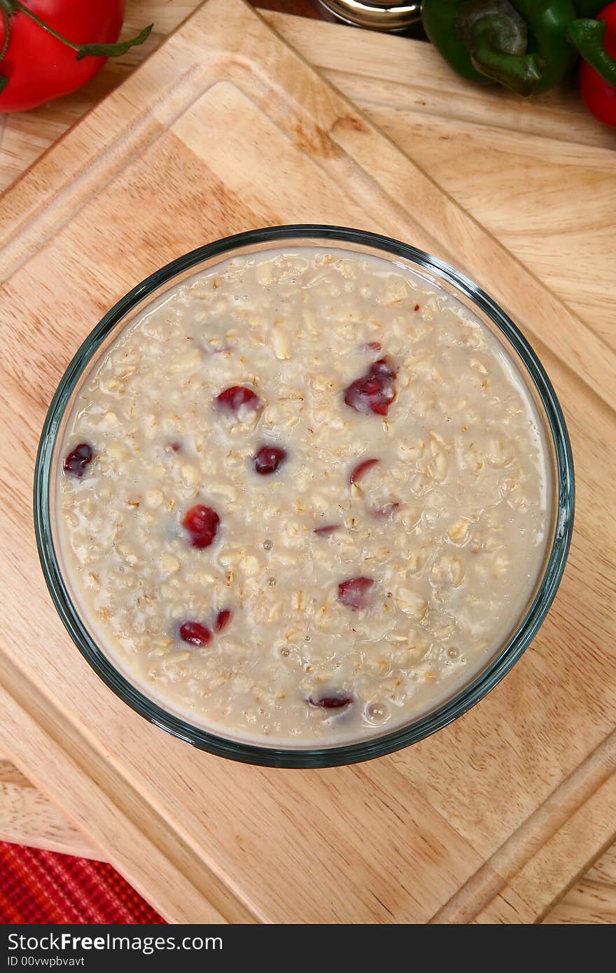 Oatmean and craisins (dried cranberries) in glass bowl in kitchen or restaurant. Oatmean and craisins (dried cranberries) in glass bowl in kitchen or restaurant.