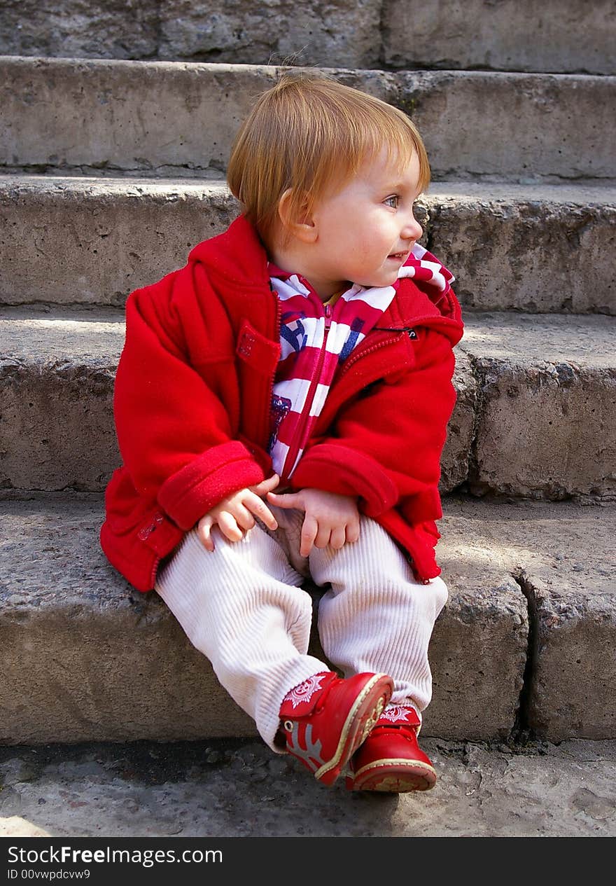 Little girl sits on a ladder