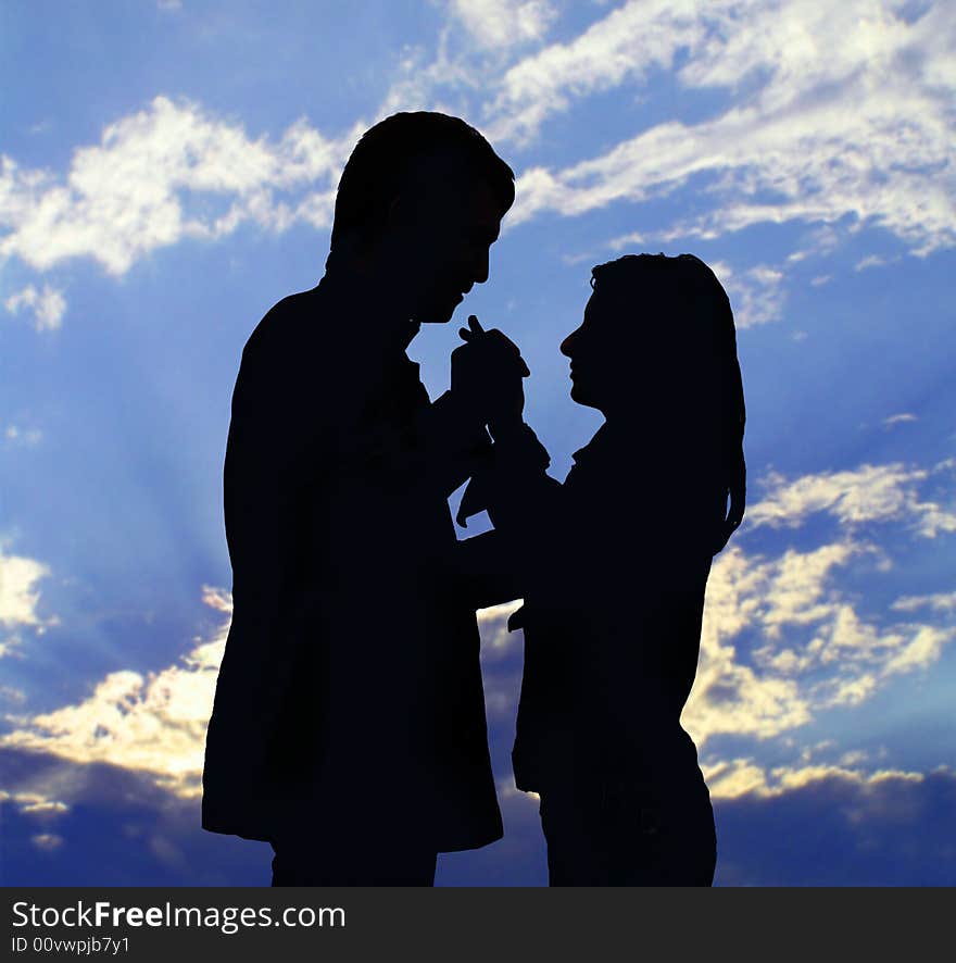 Two silhouettes. The enamoured guy and the girl on a background of the sky