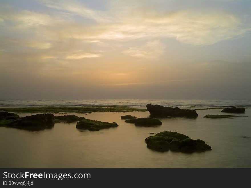 Mild orange sunset over the sea with some rocks. Mild orange sunset over the sea with some rocks