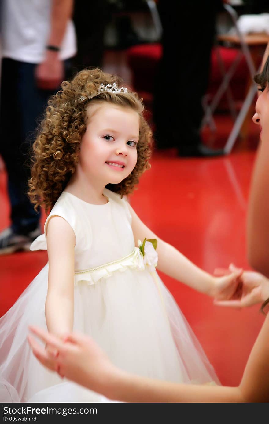 Portrait of a little, pretty girl in a white girls' gown.