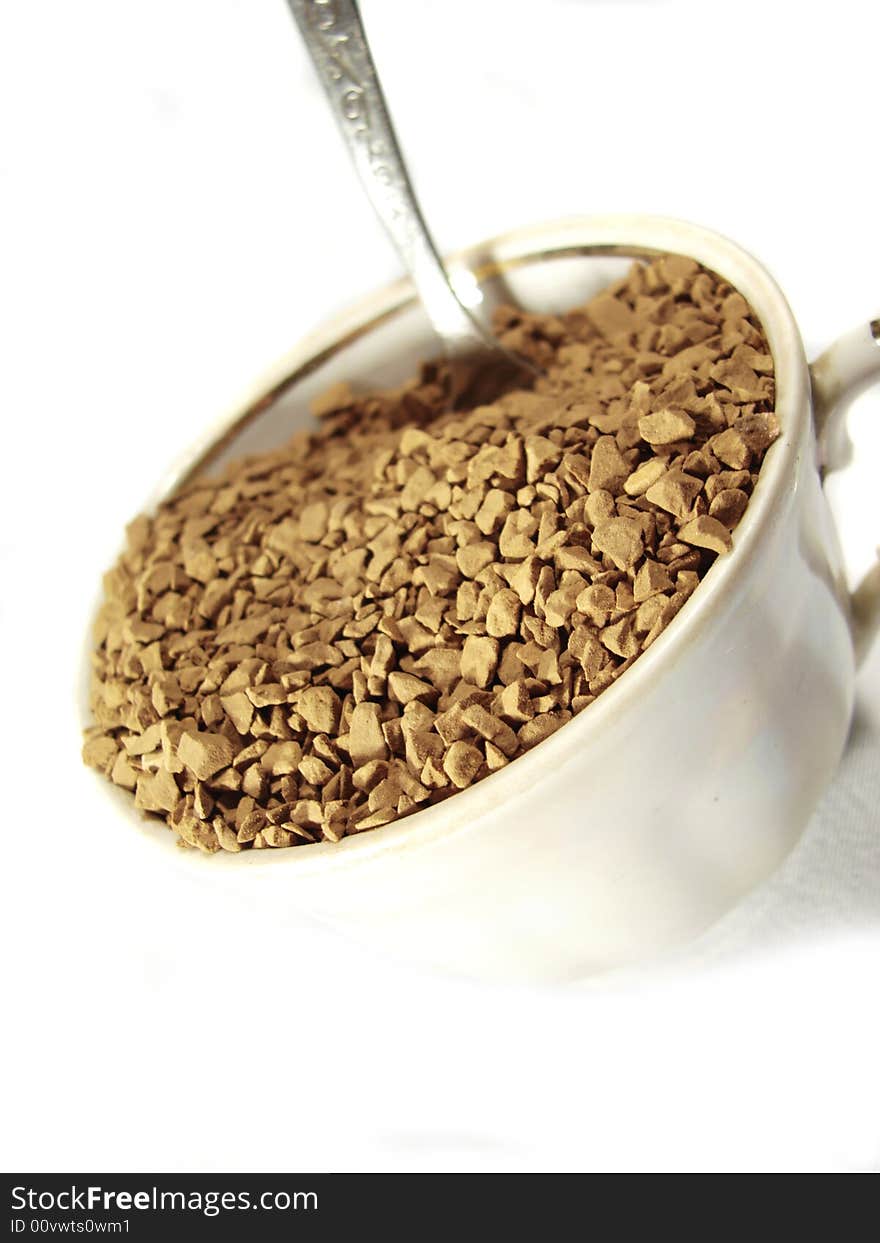 Instant coffee brown granules closeup and metal spoon. Instant coffee brown granules closeup and metal spoon