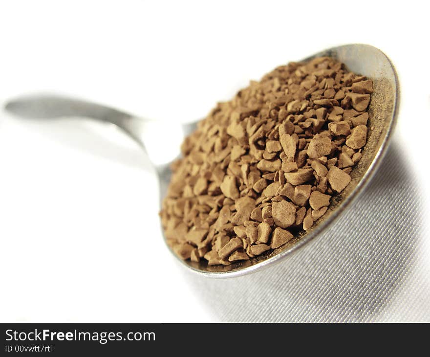 Instant coffee brown granules closeup and metal spoon. Instant coffee brown granules closeup and metal spoon