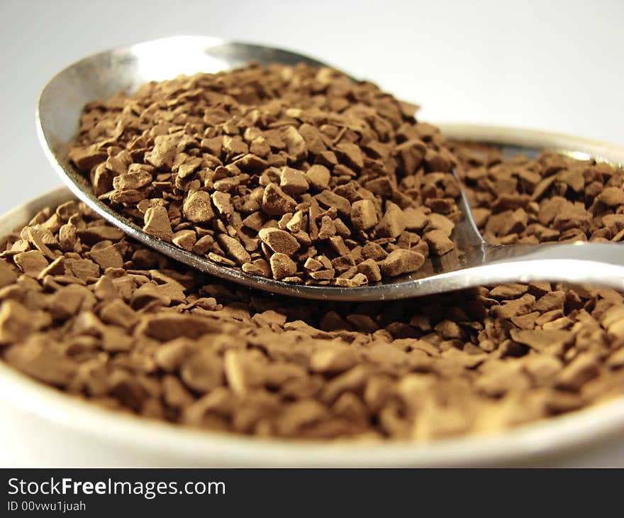 Instant coffee brown granules closeup and metal spoon. Instant coffee brown granules closeup and metal spoon