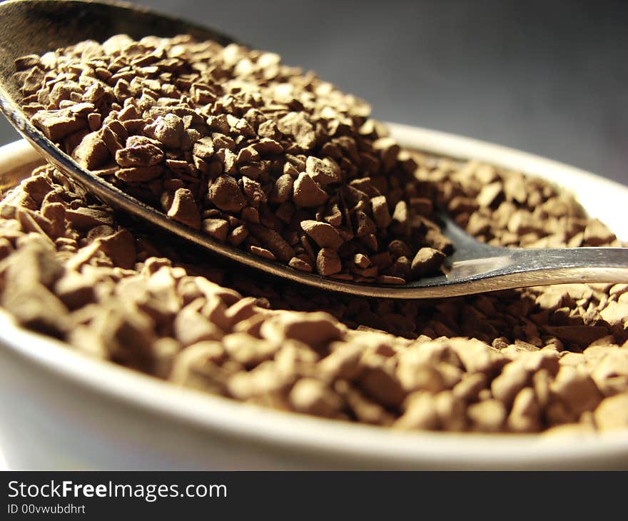 Instant coffee brown granules closeup and metal spoon. Instant coffee brown granules closeup and metal spoon