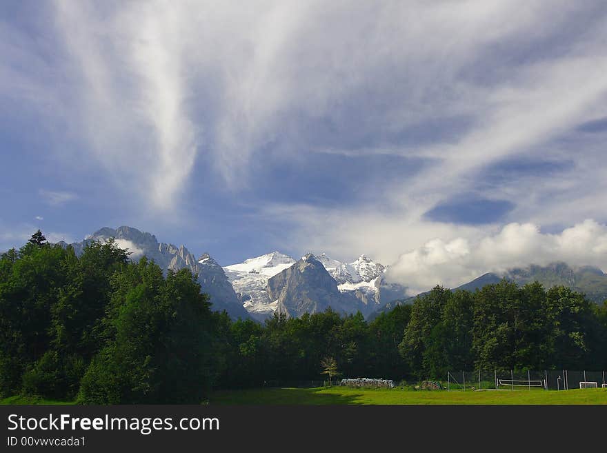 Green meadows, mountains and the blue sky. Green meadows, mountains and the blue sky