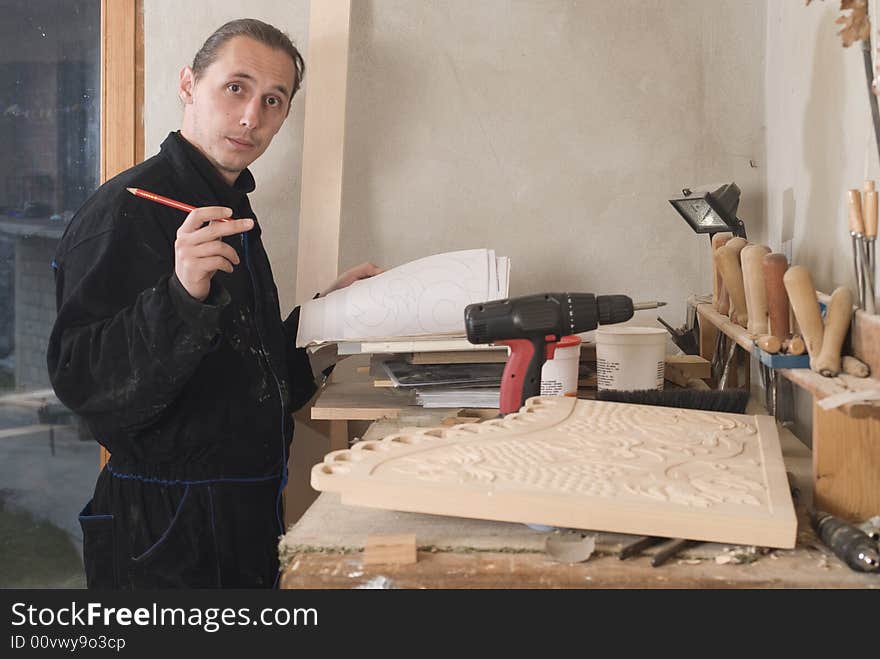 Young carpenter in his workshop with craft pencil and planning of his work