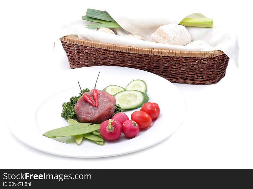 Vegetables and raw meat on a plate. Isolated on a white background