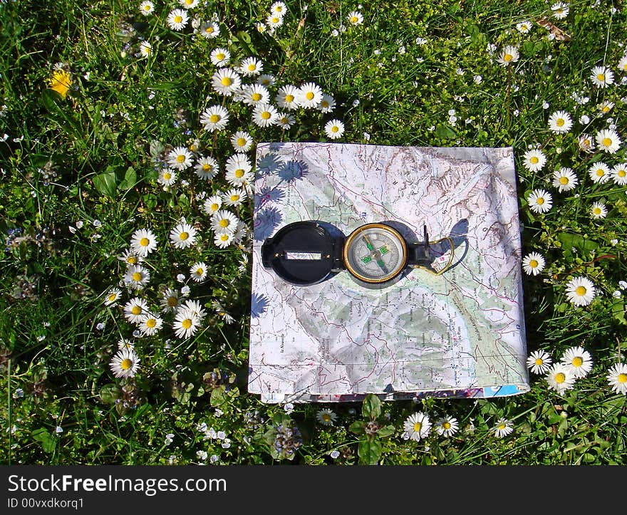 Compass and map of french mountains on grass. Compass and map of french mountains on grass