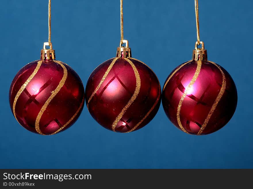 Three red New Year's spheres on a blue background