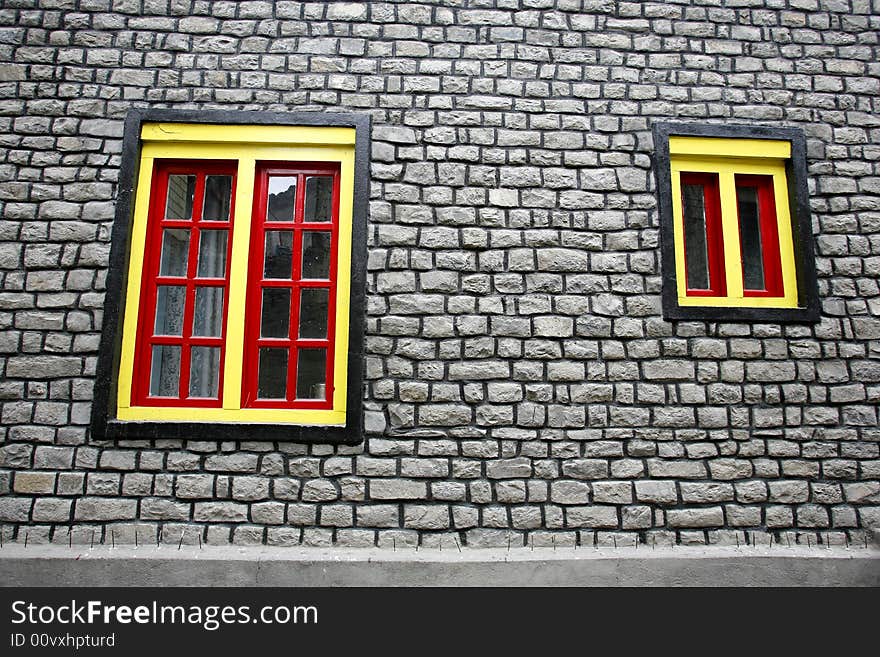 Yellow and red windows on stone wall