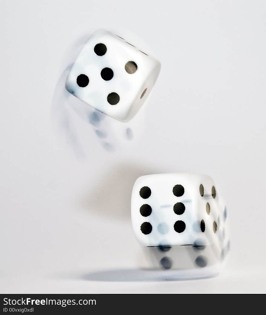 Dice been thrown on a white  background with a slow shutter speed to catch the movement trails. Dice been thrown on a white  background with a slow shutter speed to catch the movement trails