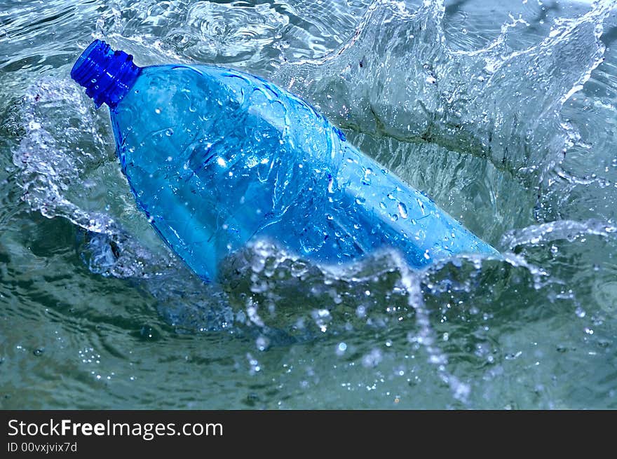 Bottle in blue water splash