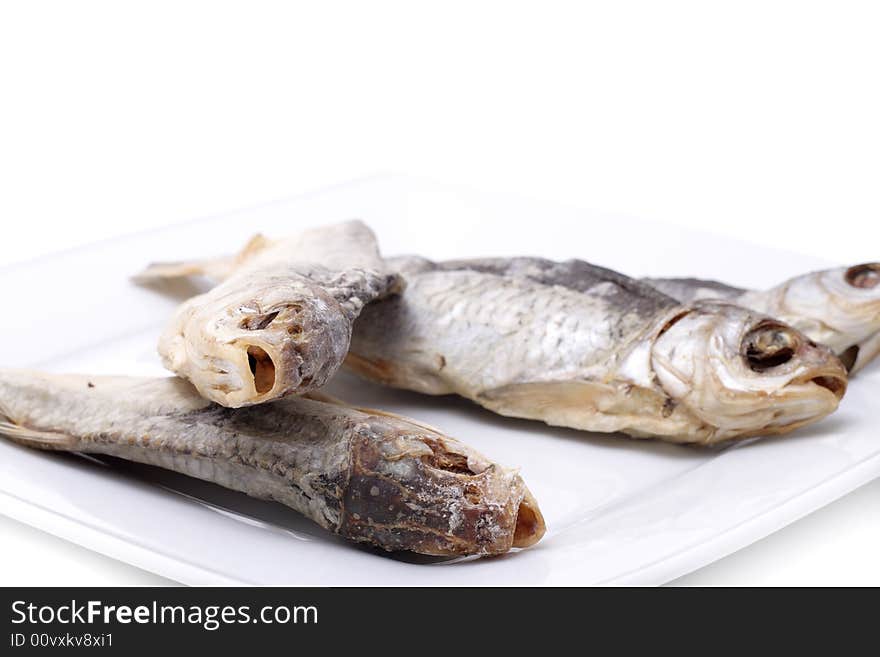 Dried fish on a plate. Isolated on a white background