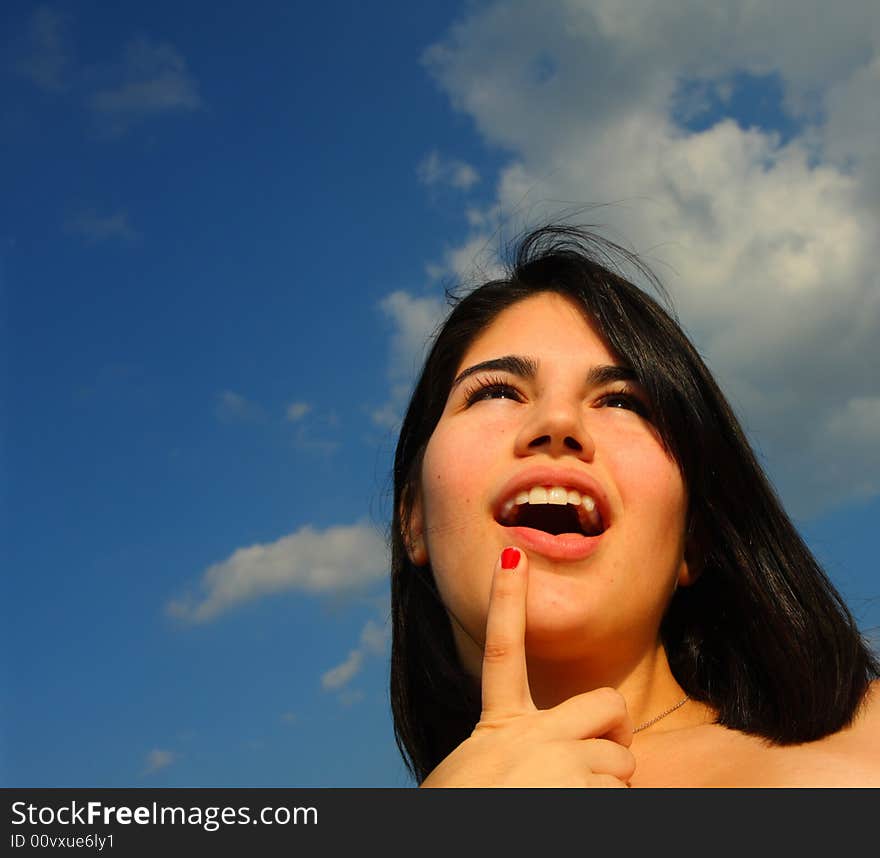 Woman looking at something with finger by her mouth. Woman looking at something with finger by her mouth.