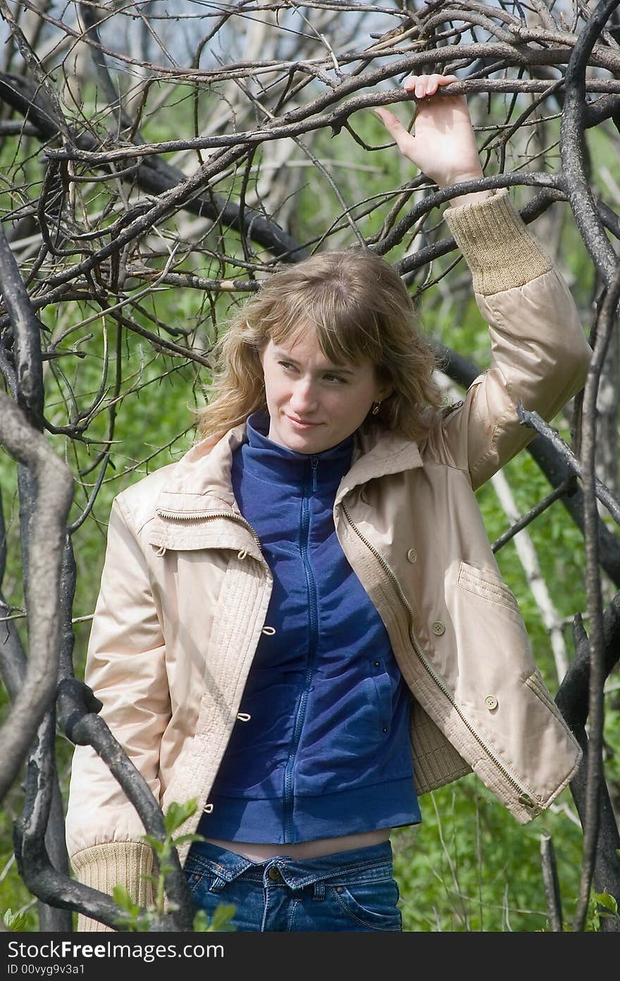 A view through the branches of a tree, focused on a pretty young teenage girl. A view through the branches of a tree, focused on a pretty young teenage girl