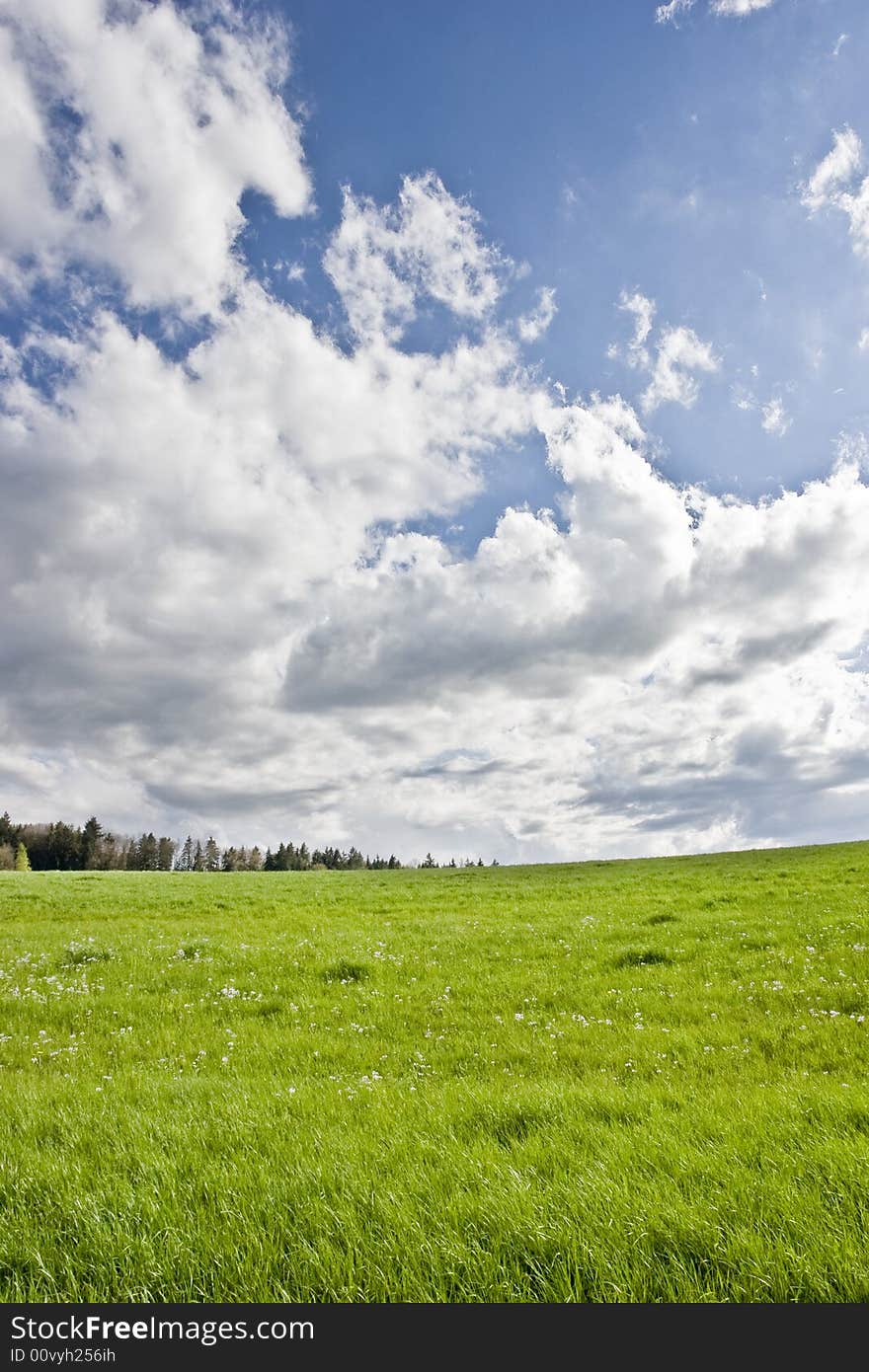 The storm is over: cloudy blue sky on green field. The storm is over: cloudy blue sky on green field