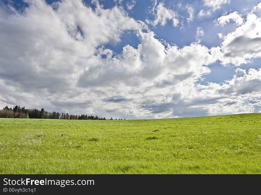 The storm is over: cloudy blue sky on green field. The storm is over: cloudy blue sky on green field