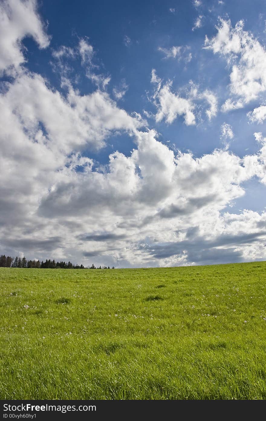 The storm is over: cloudy blue sky on green field. The storm is over: cloudy blue sky on green field