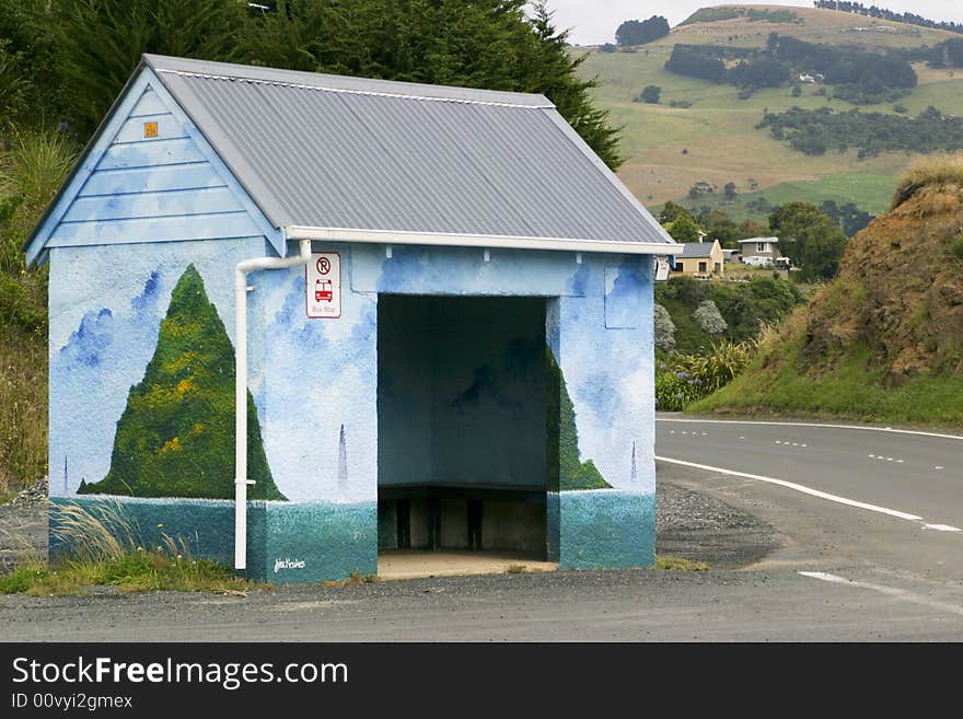 A brightly painted bus stop shelter in the country. A brightly painted bus stop shelter in the country