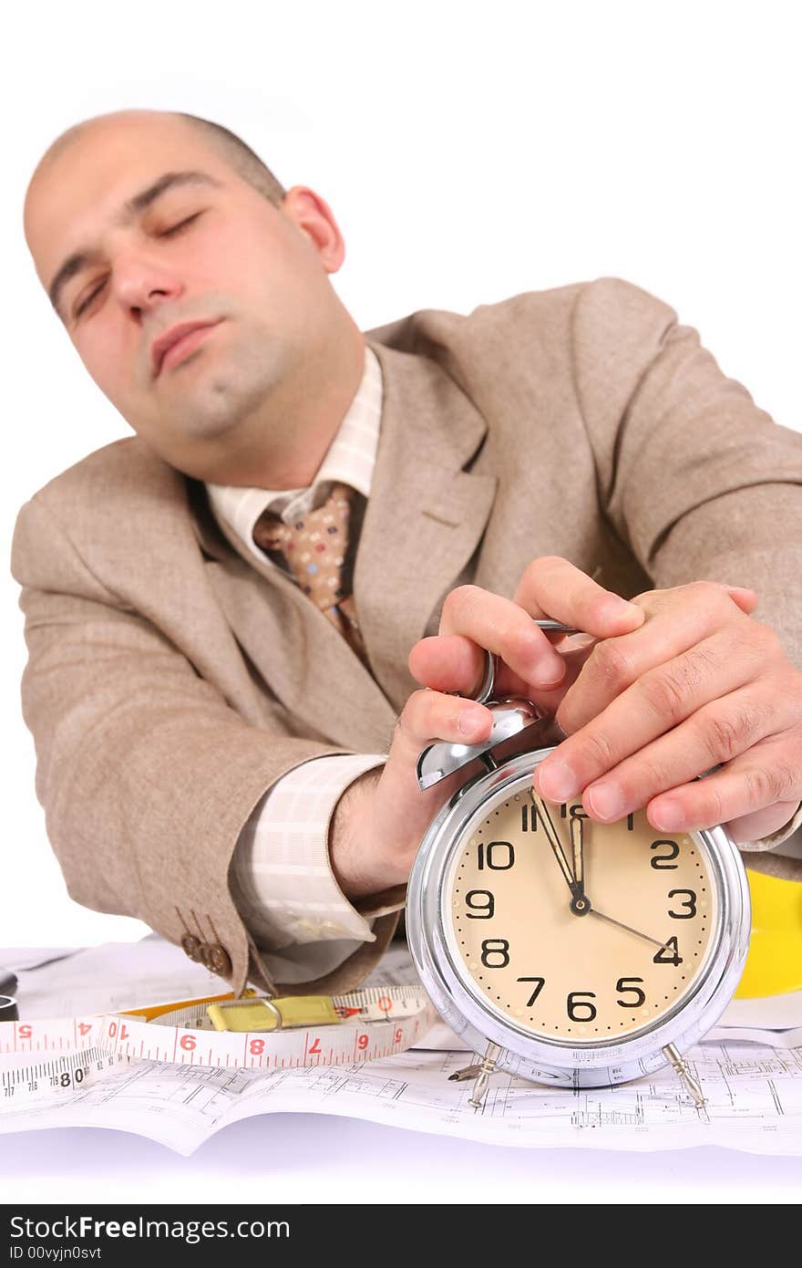 A businessman sleepy with architectural plans at desk