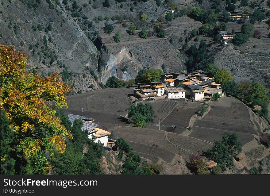 Village and field at the top of a sheer cliff.