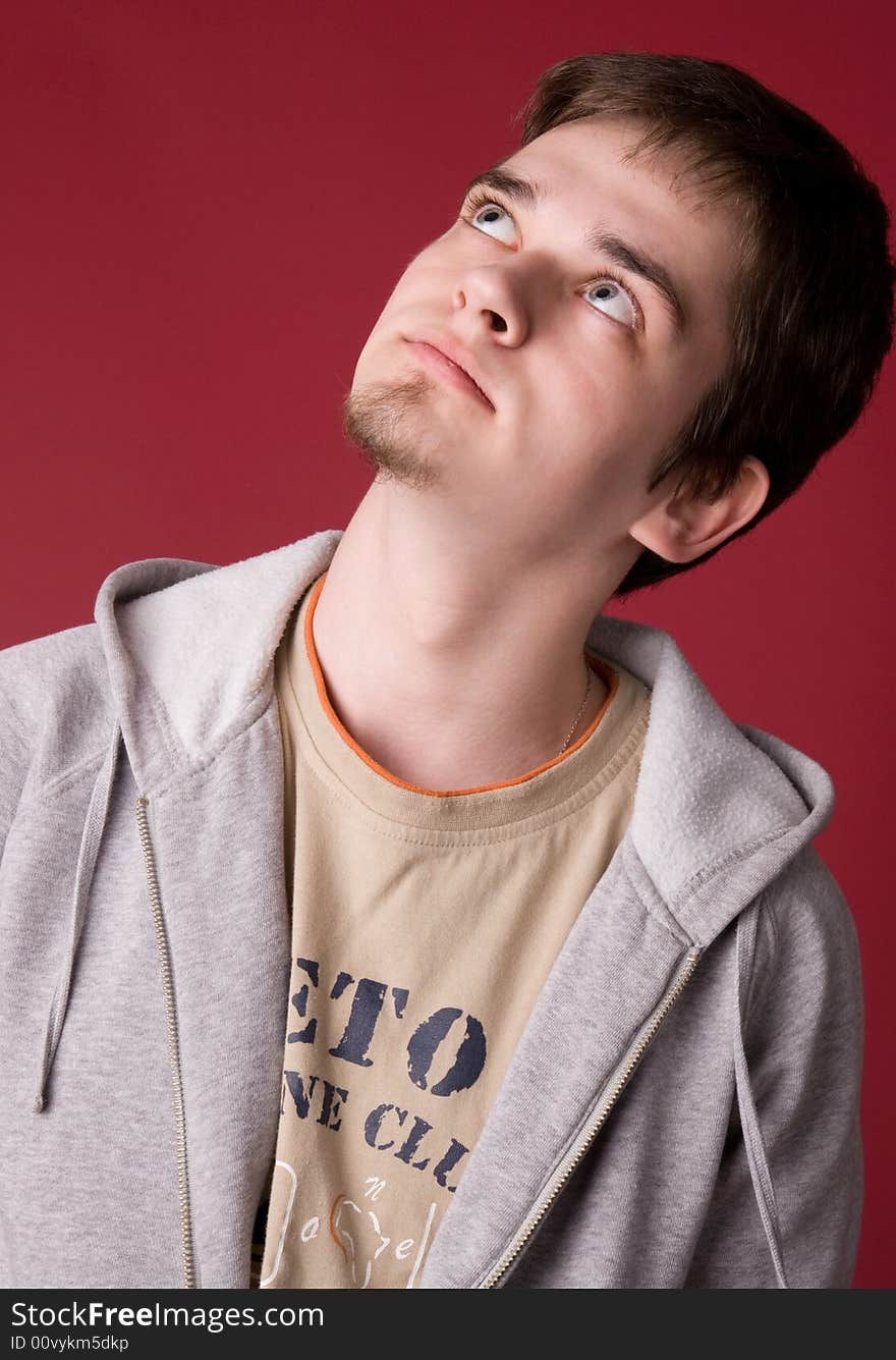 The young guy in studio on a red background