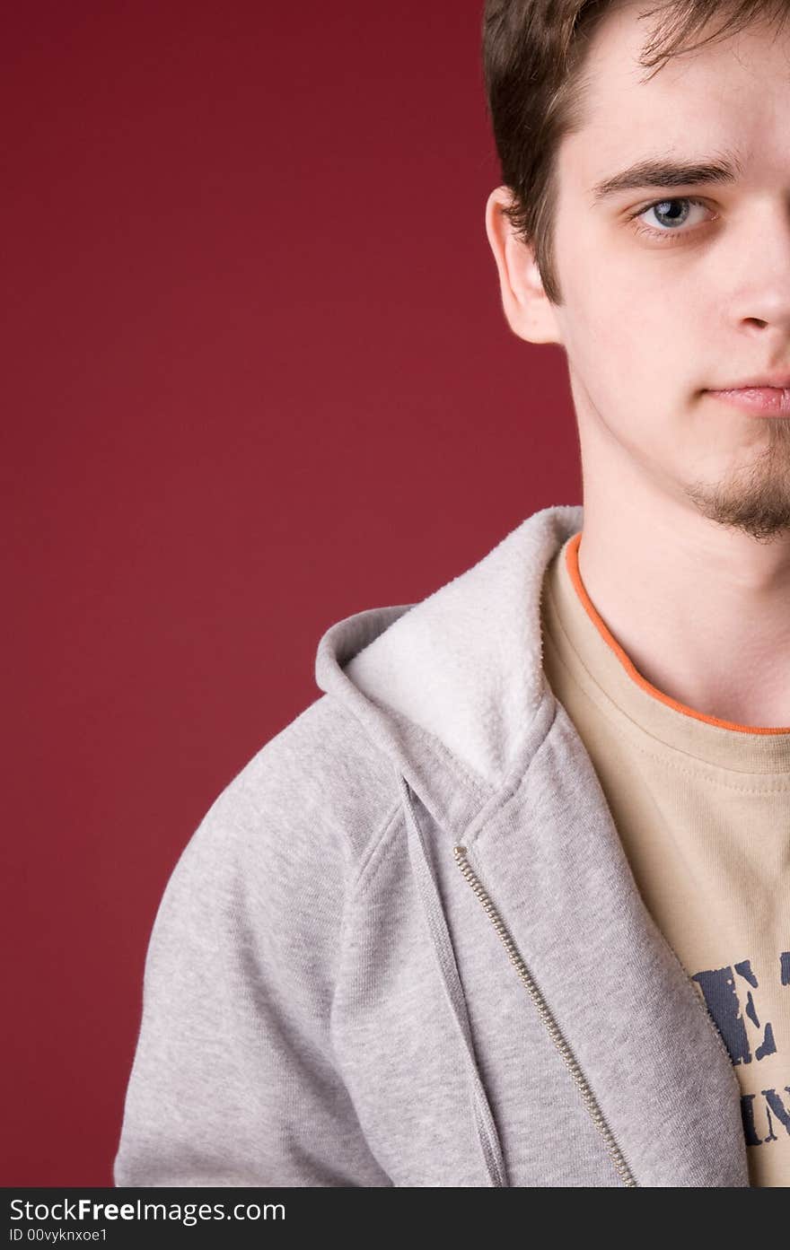 The young guy in studio on a red background