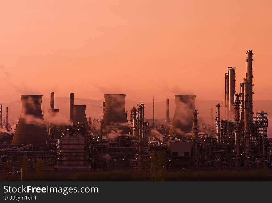 A view of the smoking chimney stacks of Grangemouth Oil Processing Plant/Refinery at sunset. A view of the smoking chimney stacks of Grangemouth Oil Processing Plant/Refinery at sunset.