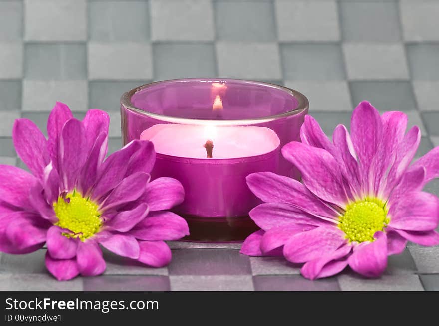 Spa candle with flowers on grey background