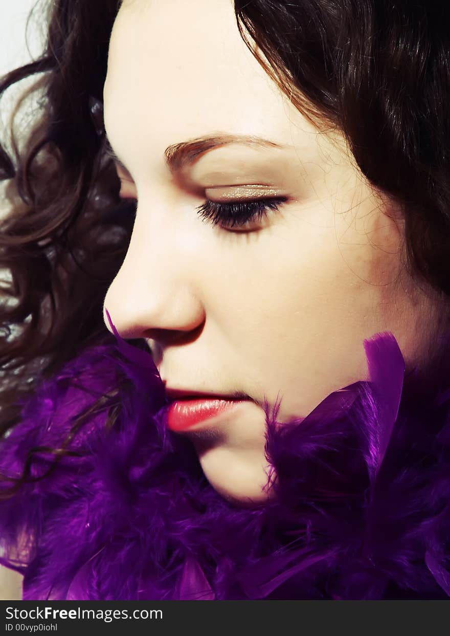 A portrait about a pretty lady with white skin, long brown wavy hair and a scarf made with vivid purple feathers. A portrait about a pretty lady with white skin, long brown wavy hair and a scarf made with vivid purple feathers