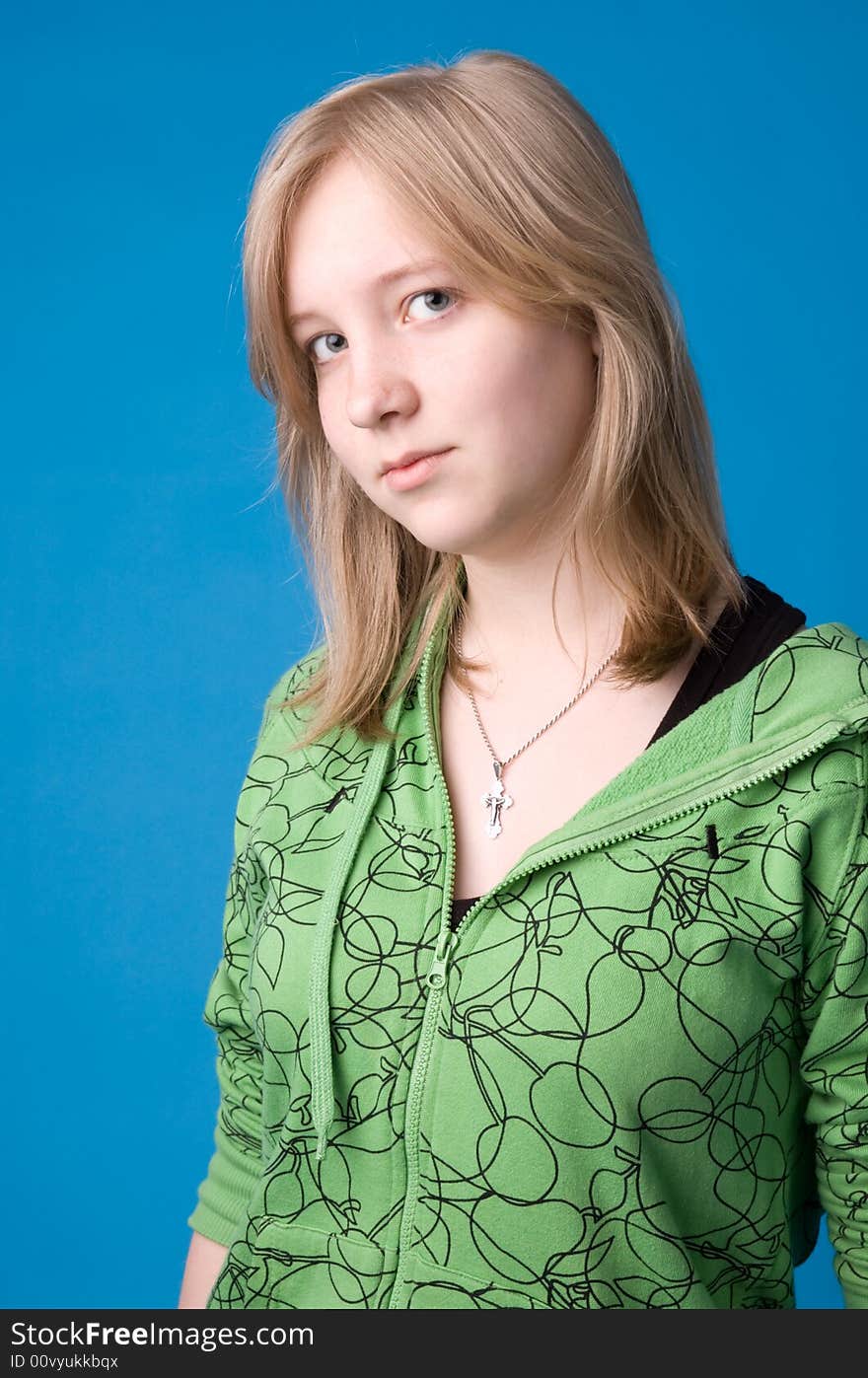 The young girl in green clothes on a dark blue background. The young girl in green clothes on a dark blue background.