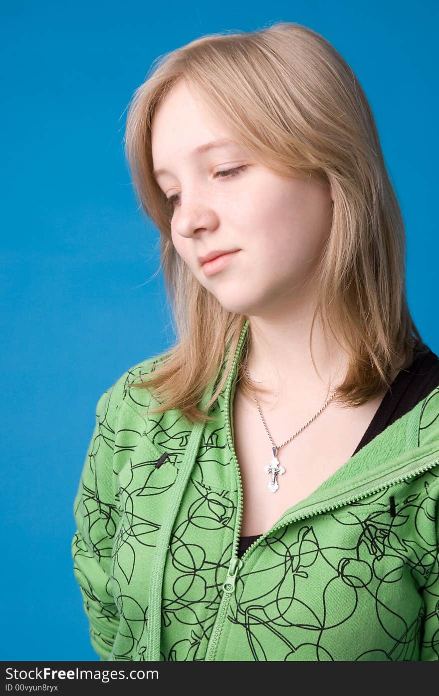 The young girl in green clothes on a dark blue background. The young girl in green clothes on a dark blue background.