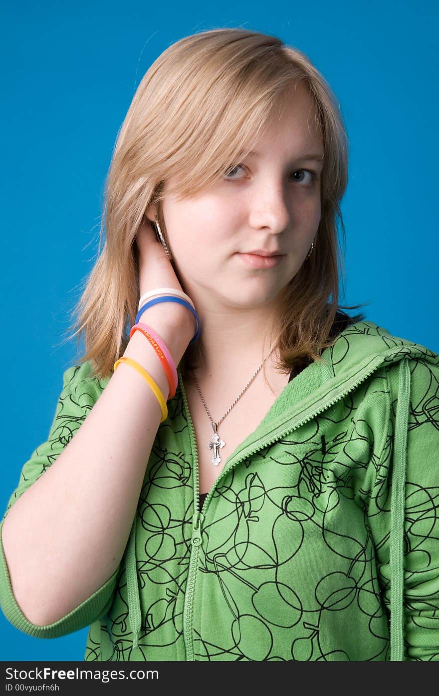 The young girl in green clothes on a dark blue background. The young girl in green clothes on a dark blue background.