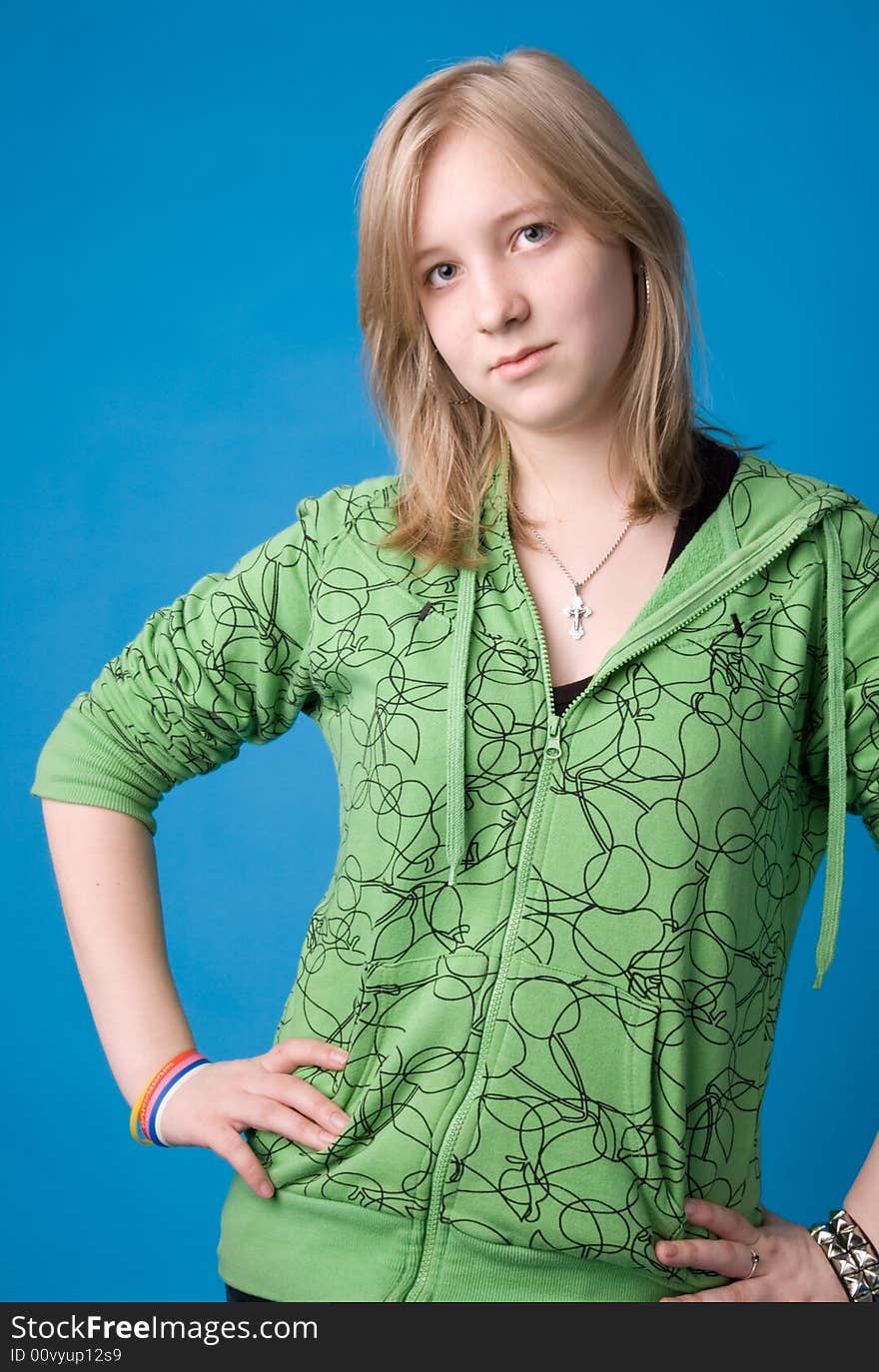 The young girl in green clothes on a dark blue background. The young girl in green clothes on a dark blue background.