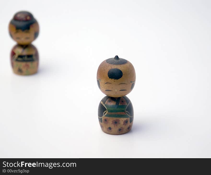 Two wooden Japanese figures on a white background. Two wooden Japanese figures on a white background.