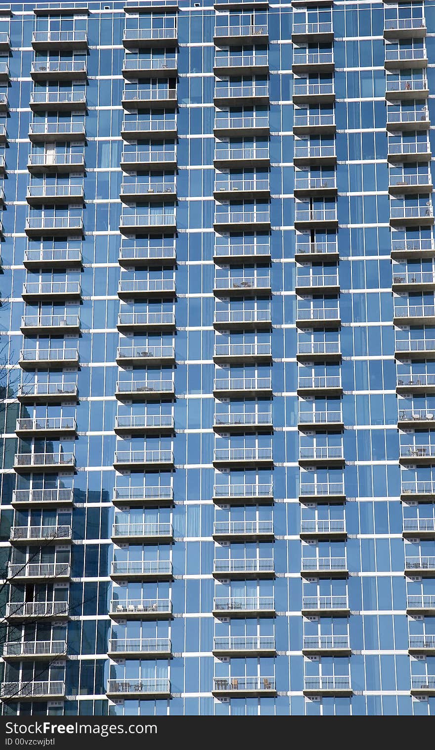 A blue glass wall apartment full of balconies. A blue glass wall apartment full of balconies