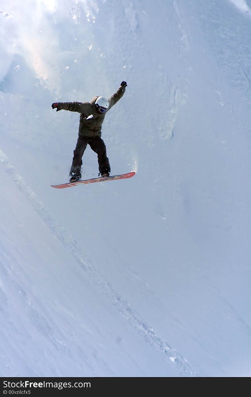 A snowboarder drops in from a high level cornice. Freefalling with powder and snow debrit cascading down from above. A snowboarder drops in from a high level cornice. Freefalling with powder and snow debrit cascading down from above.