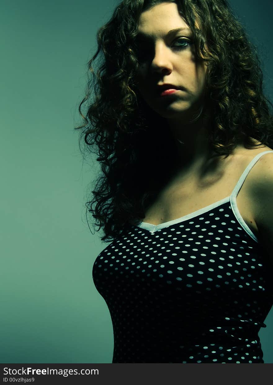 A low-key portrait about a pretty lady with white skin and long brown wavy hair whose look is glamorous and she wears a nice black dress with white dots. A low-key portrait about a pretty lady with white skin and long brown wavy hair whose look is glamorous and she wears a nice black dress with white dots