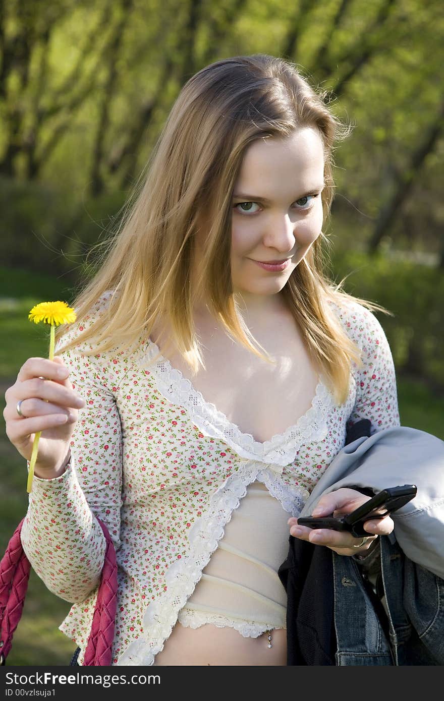 Young Woman with Mobile and flower in park. Young Woman with Mobile and flower in park