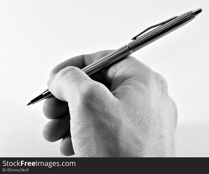 Photo of a hand holding a pen just about to write a letter. Photo of a hand holding a pen just about to write a letter