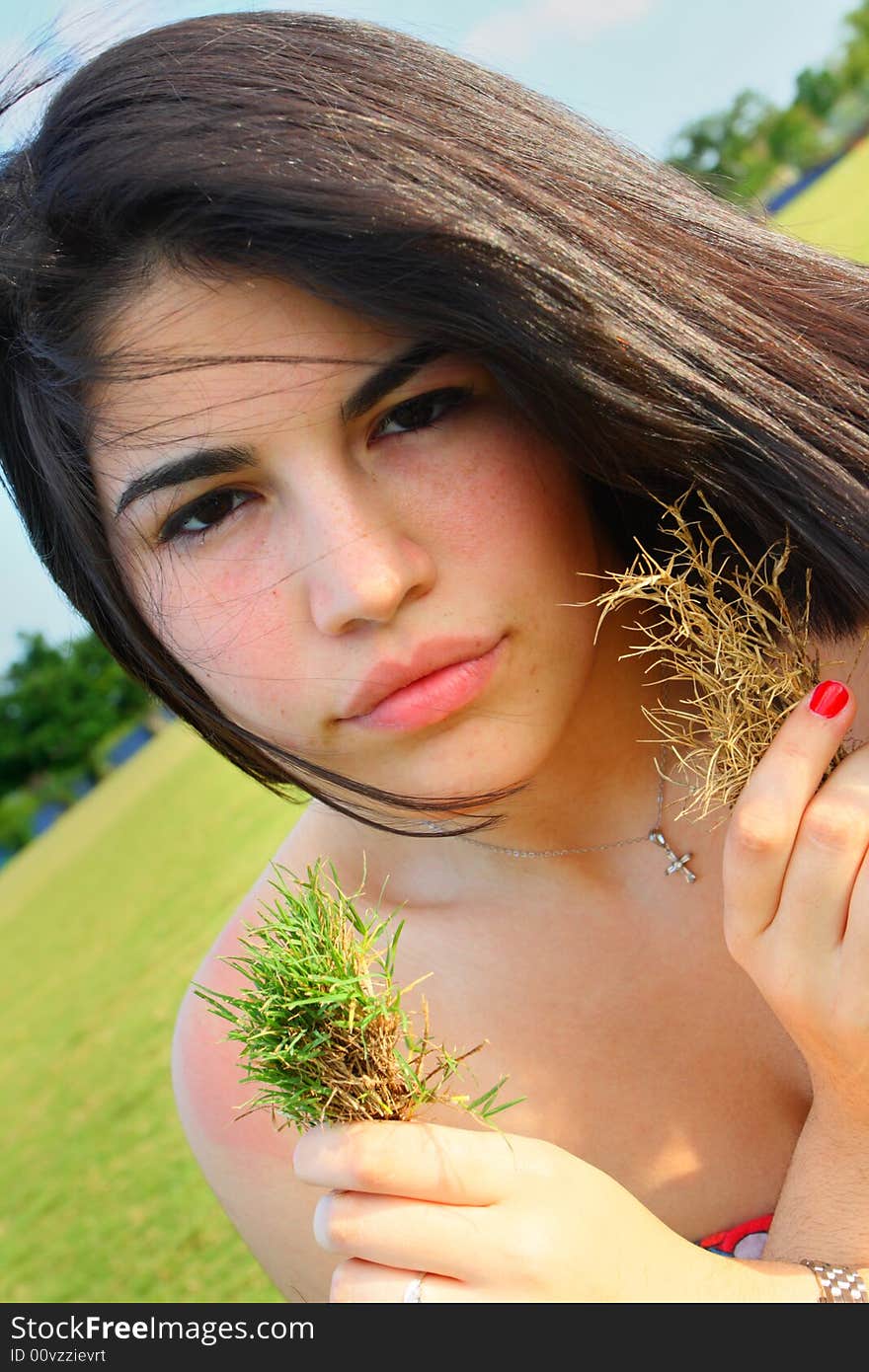 Woman holding a live and dead patch of grass. Woman holding a live and dead patch of grass.