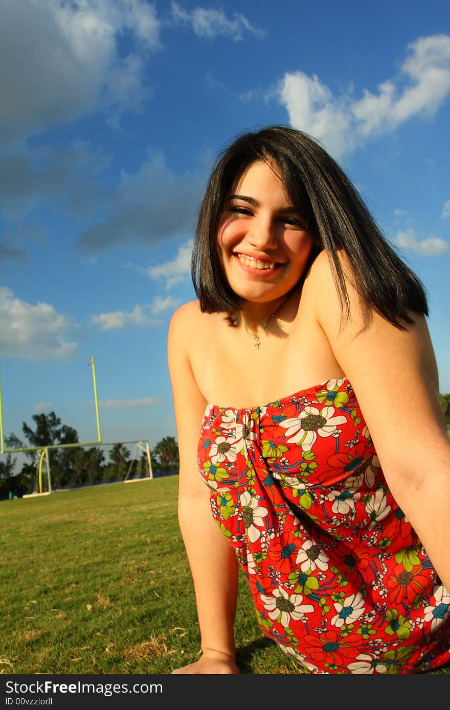 Woman on the grass with her legs behind her body. Woman on the grass with her legs behind her body.